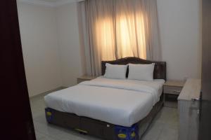 a bedroom with a large bed with white sheets and pillows at RED Royal Inn in Salalah +23 photos