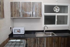 a small kitchen with a sink and a microwave at RED Royal Inn in Salalah