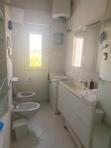 ランペドゥーザにあるラ サリーナの白いバスルーム(洗面台、トイレ付)