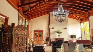 una sala de estar con una lámpara de araña colgando del techo en Chamame - Pousada em Bonito, en Bonito