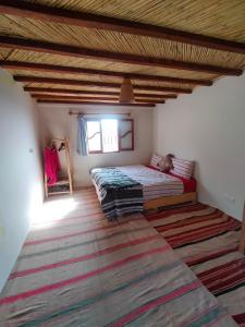 a bedroom with a bed and a rug on the floor at Gite Gliz in Marrakech