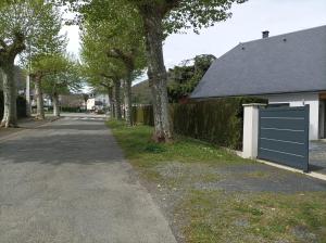 a street with a fence and a blue garage at Maison Lys in Argelès-Gazost