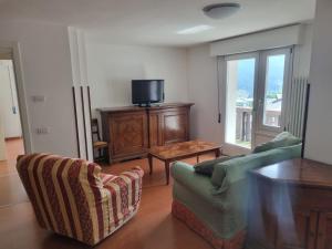 皮耶韋迪卡多雷的住宿－La Casa di Paolo, Pieve di Cadore centro，客厅配有两把椅子和电视
