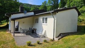 a small white house with a table and chairs at Landhaus Wald und See Nr. 35 in Biersdorf