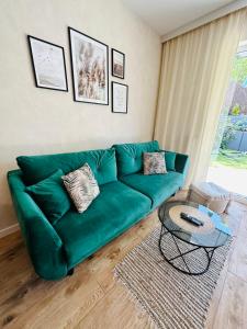 un divano verde in un soggiorno con tavolo di LuxFlats Apartament LUX a Jastrzębia Góra