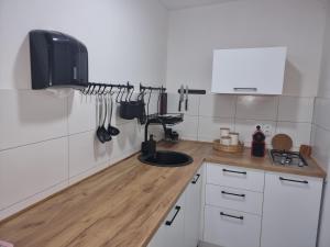 cocina con armarios blancos y encimera de madera en EKO HOUSE en Kaludjerske Bare