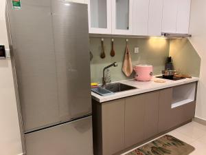 a kitchen with a sink and a refrigerator at Vinhome Grand Park Homestay-HappyStay in Gò Công