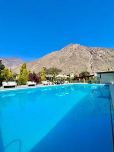 a large swimming pool with a mountain in the background at Hotel Magdalena Campestre in Santa Rosa de Quives