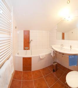 a bathroom with a tub and a sink at Schi- und Wanderhotel Berghof in Bad Kleinkirchheim