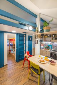 a kitchen with blue walls and a table and chairs at Boho House 4 in camp Terme Catez in Čatež ob Savi