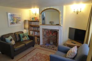 a living room with a couch and a fireplace at Loom Cottage in Southwold