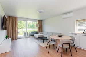 a living room with a table and a couch at Emgus cottages (Nature & Comfort) in Palanga
