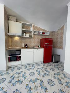 a kitchen with a red refrigerator and a tile floor at Caterina 70 in Naples