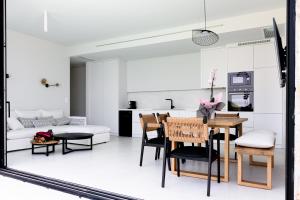 cocina y sala de estar con mesa y sillas en Mandevilla Hillside Luxury Villas en Áyios Nikítas