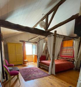 1 dormitorio con cama con dosel en el ático en L'Arbre penché, en Bassoues