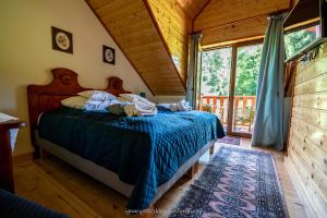 a bedroom with a bed and a large window at Ranczo w Rabe in Czarna
