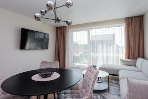 a living room with a table and a couch at Emgus cottages (Nature & Comfort) in Palanga