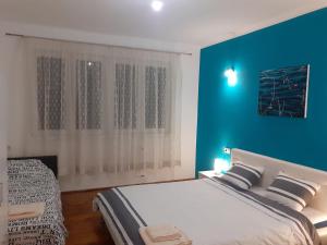 a bedroom with a large bed with a blue wall at Lep apartman TARA -Kremna in Kremna