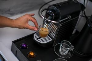a person is making a drink in a mixer at Anemone Premium Suites Faliraki in Faliraki