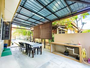 a patio with a table and chairs and a sink at Ujana Damai - Cosy 5 bedrooms near UMT UNISZA in Kuala Terengganu