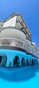 un gran edificio con una piscina frente a él en Hotel B&B Negresco, en Milano Marittima