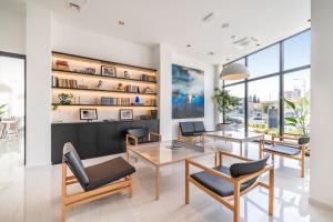 a living room with tables and chairs and windows at Miramare Hotel in Zadar