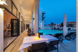 a dining room with a table and a swimming pool at Miramare Hotel in Zadar
