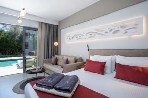 a bedroom with a large bed with red pillows at Anemone Premium Suites Faliraki in Faliraki