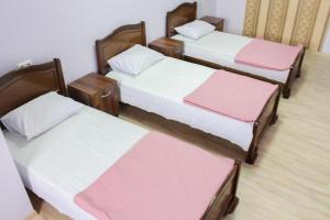 a group of three beds in a room at GoriHouse in Gori