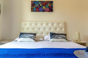 een slaapkamer met een groot bed en een blauwe deken bij Villetta Mari e Amuri in Giardini Naxos