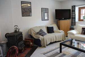 a living room with a couch and a wood stove at LA CHAUMIERE DE TAVOU in Cornimont