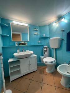 a blue bathroom with a sink and a toilet at Caterina 70 in Naples