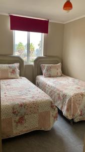 a bedroom with two beds and a window at RESETEATE EN FAMILIA ALGARROBO in Algarrobo