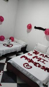 una habitación con 2 camas con corazones rojos en las sábanas en Hotel El Paisano en Villavicencio