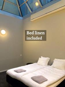 a bed in a room with a bedini included sign on the wall at Grad Hotel and Hostel in Stockholm