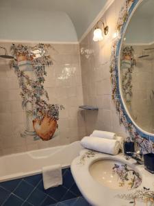 Palazzo Rocco - Golden Suite - Praiano - Amalfi Coast في برايانو: حمام مع حوض ومرآة وحوض استحمام