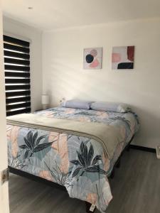 a bedroom with a bed and two pictures on the wall at COSTA LOBO ll in Pichilemu +39 photos