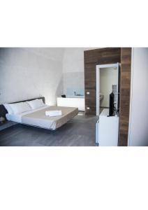 - une chambre avec un lit et un grand miroir dans l'établissement Il Cocchiere, à Palagianello