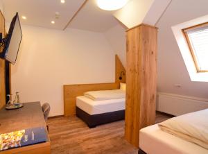 Mały pokój z 2 łóżkami i biurkiem w obiekcie Hotel Gasthof Krone w mieście Spalt
