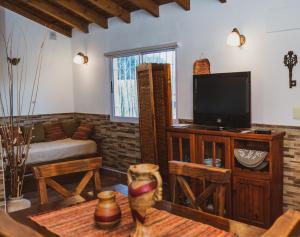 a living room with a couch and a television at Cabañas Morada del Cerro -Cabaña Algarrobo- in Capilla del Monte