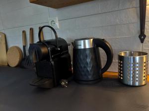 Seastone في إيريسوس: وعاء قهوة أسود وفضي وكوب على منضدة