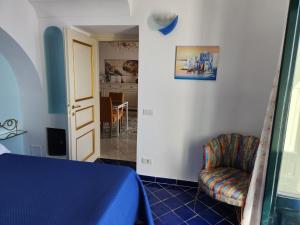 sypialnia z łóżkiem i krzesłem w pokoju w obiekcie Palazzo Rocco - Golden Suite - Praiano - Amalfi Coast w mieście Praiano