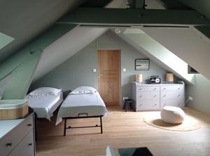 a attic bedroom with two beds and a staircase at Charmante maison familiale avec piscine in Cour-Cheverny
