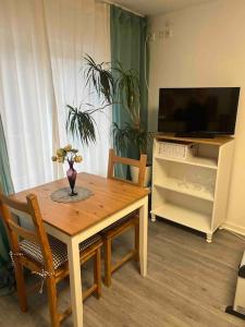 ein Wohnzimmer mit einem Holztisch und einem TV in der Unterkunft Apartment am Rotweinwanderweg in Bad Neuenahr-Ahrweiler