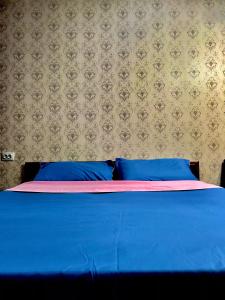 a blue bed with blue pillows in a bedroom at Apartaments in the city center in Karagandy