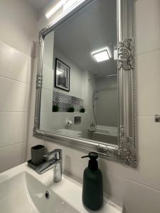 uma casa de banho com um espelho e um lavatório em Apartament Wroclawia em Breslávia