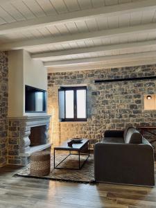 a living room with a couch and a brick wall at Manifest Boutique Hotel in Oitylo