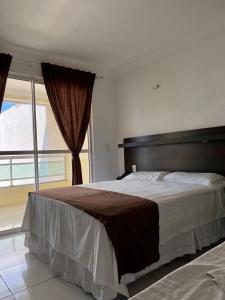sypialnia z dużym łóżkiem i dużym oknem w obiekcie SP Hotel Fortaleza w mieście Fortaleza