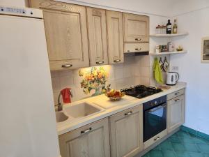a kitchen with wooden cabinets and a sink and a stove at Palazzo Rocco - Golden Suite - Praiano - Amalfi Coast in Praiano