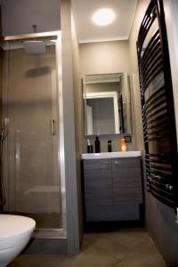 a bathroom with a sink and a shower with a mirror at Mucenieku Apartamenti in Kuldīga